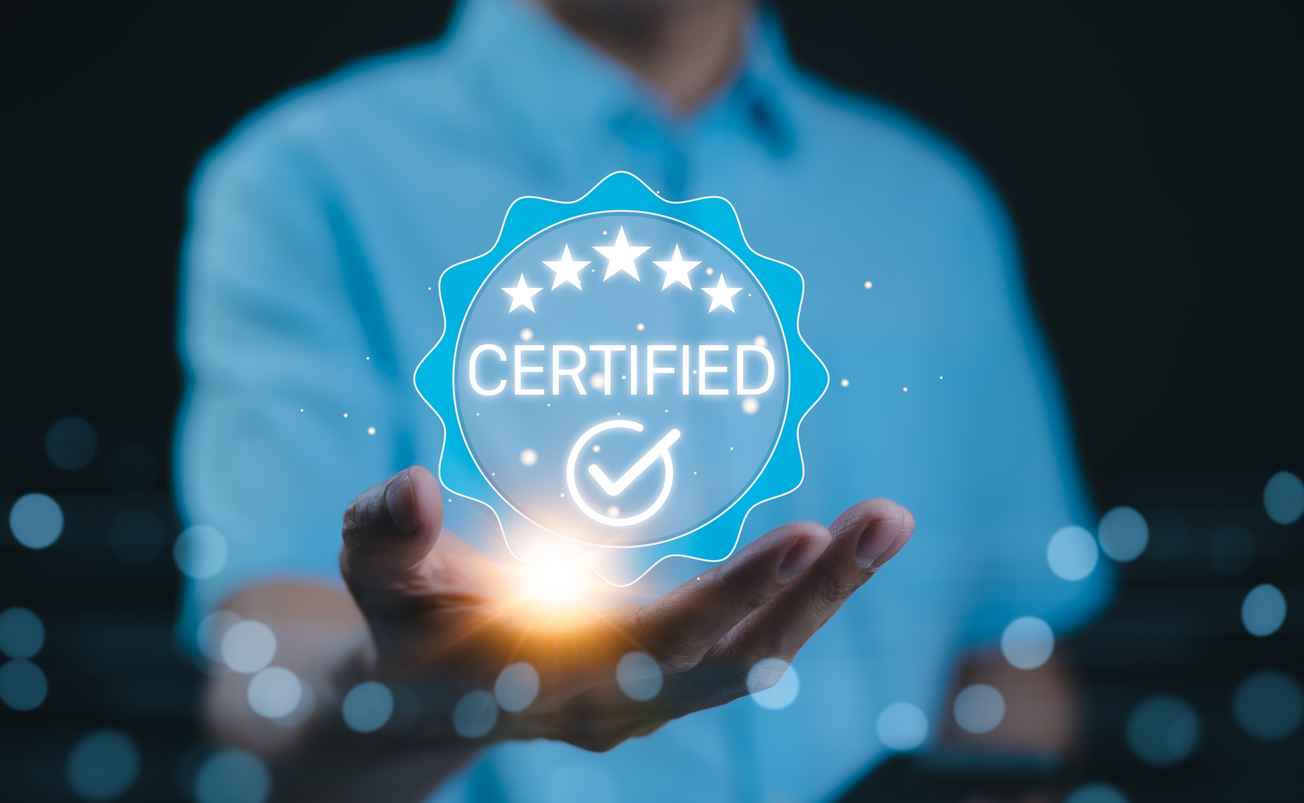 Certified concept. A person holds a glowing holographic badge displaying the word Certified with a checkmark and stars, symbolizing quality assurance, accreditation, and validation. ISO Certified,