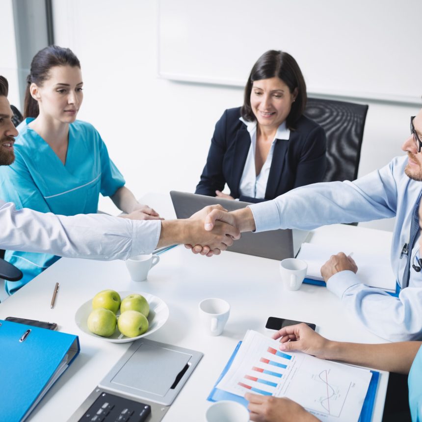 Doctors shaking hands with each other in meeting at conference room